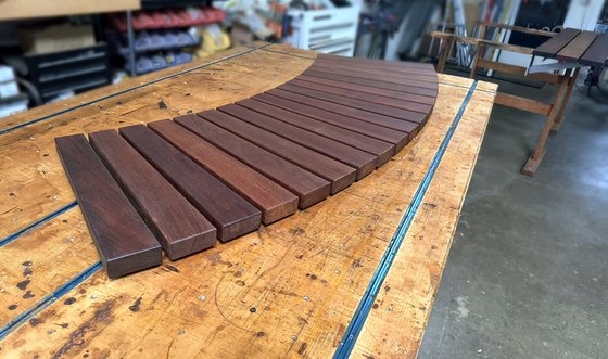 The curved Seatwall seat on the assembly table, its straight Cantilever Wall partner behind